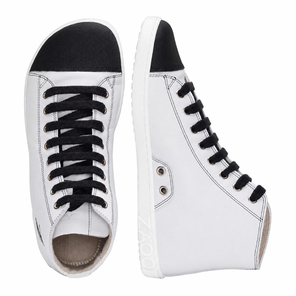 Vi præsenterer CHUQQS White fra ZAQQ: et par elegante hvide højtop-sneakers med sorte snørebånd og tåkapper. Den venstre sko ses oppefra og ned, mens den højre sko står oprejst og viser sin sideprofil. Disse sneakers er fagligt fremstillet af nappalæder og har hvide såler med mærkenavnet ZOOZ.