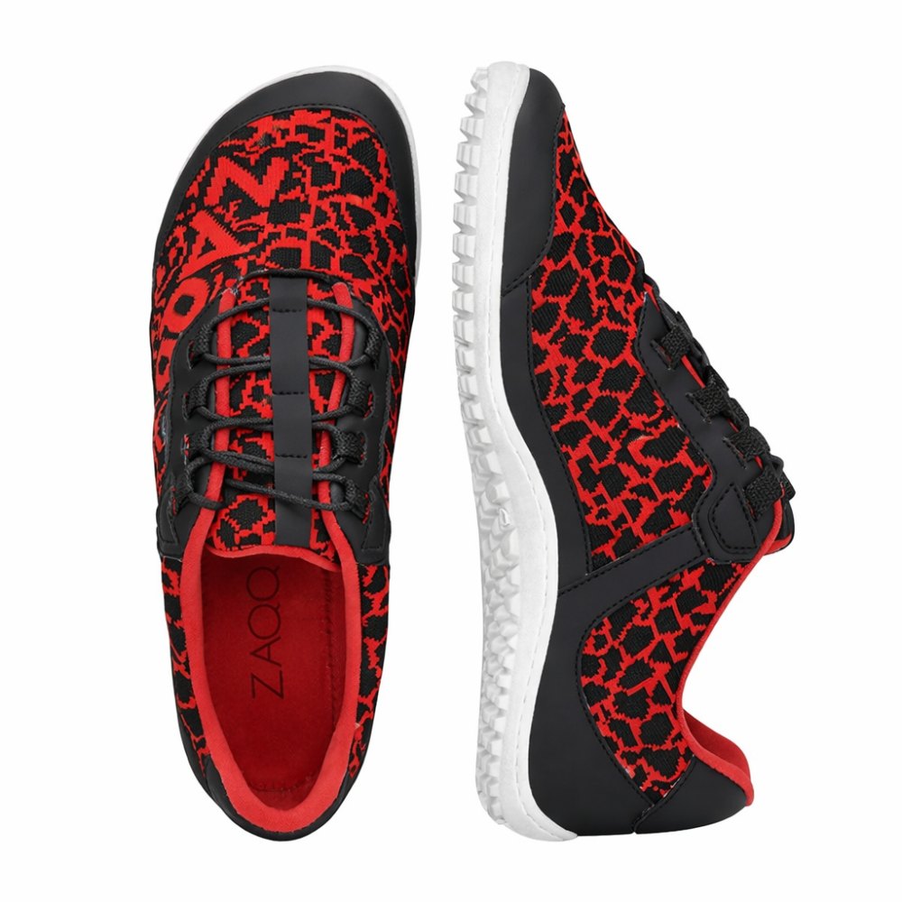 Die QASEY Red Sneaker von ZAQQ sind ein Paar stylische vegane Barfußschuhe in Rot, verziert mit einem schwarzen geometrischen Muster. Sie verfügen über flexible Gummisohlen, schwarze Schnürsenkel und ein einzigartiges Profildesign. Ein Sneaker ist von oben abgebildet, während der andere von der Seite gezeigt wird, um sein schlankes Design zu präsentieren.