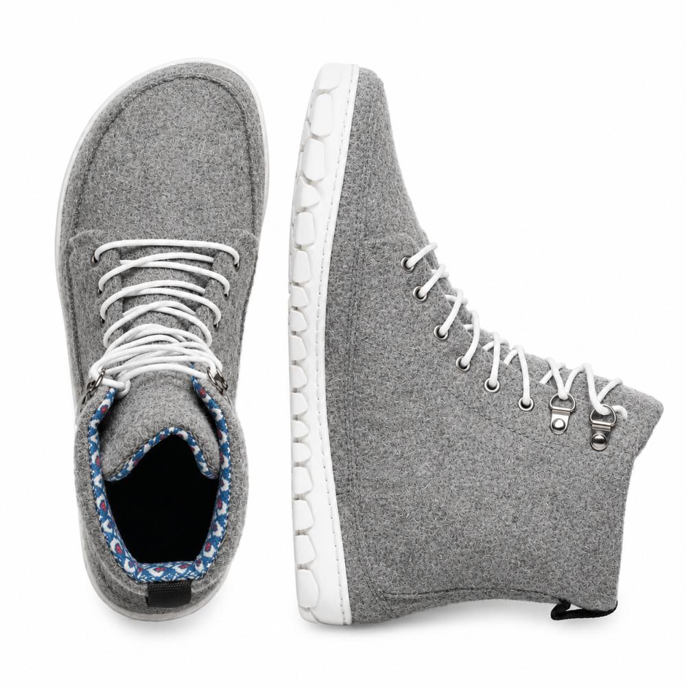 Vi præsenterer QICE Grey fra ZAQQ: Disse sneakers har et high-top design i grå med hvide snørebånd og giver et godt udsyn både fra toppen og fra siden. Deres fremtrædende træk er en unikt struktureret udendørssål, der giver mere stil og komfort. De er lavet af materialer, der ligner merinould, og tilbyder en iøjnefaldende blanding af komfort og mode.